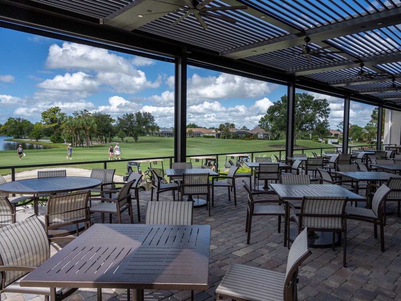 The covered, screened Sunset Terrace overlooking the golf course at sunset